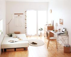 a bedroom with white walls and wooden floors