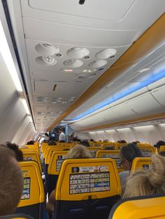 an airplane with people sitting on seats and looking at the ceiling in the back area