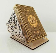 an open book with arabic writing on the front and inside, sitting on top of a white surface