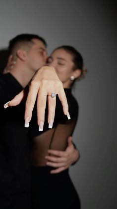 a man and woman kissing with their fingers touching each other