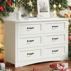 a white dresser sitting in front of a christmas tree