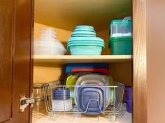 an open cabinet filled with dishes and cups