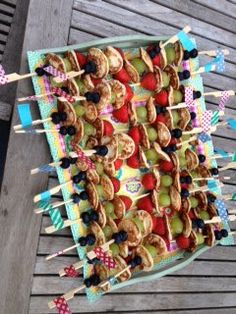 an assortment of desserts are displayed on a table with toothpicks and strawberries