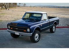 a blue pick up truck parked in a parking lot