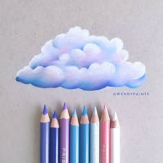 colored pencils lined up in front of a drawing of a cloud