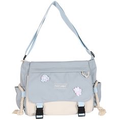 a gray and white purse with sheep patches on it's shoulder strap, hanging from the side