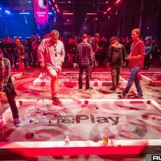 a group of young men standing on top of a video game platform in front of a crowd