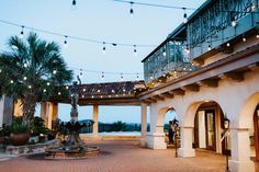 an outdoor courtyard with lights strung over it