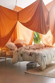 an orange canopy over a bed in a bedroom