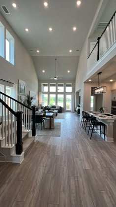 a large open floor plan with wood floors and white railings