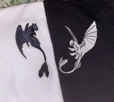 two black and white shirts with dragon embroidered on them, one in the shape of a bird