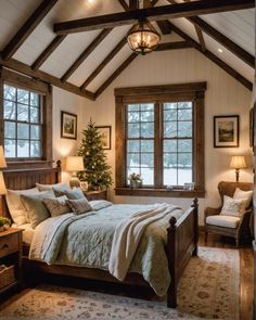 a bed sitting under a window in a bedroom next to a chair and table with a christmas tree on it