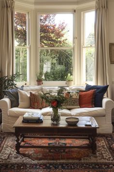 a living room filled with furniture and a large window covered in windowsills next to a rug