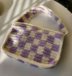 a crocheted purse sitting on top of a white plate