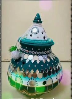 there is a colorful vase that has been decorated with beads and sequins on it