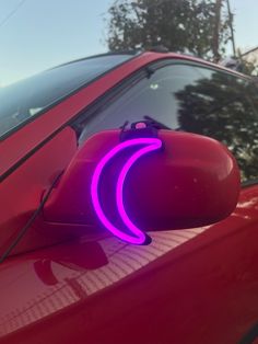 the reflection of a car's side view mirror with a purple light on it