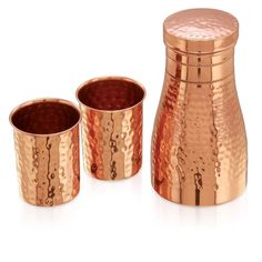 three copper colored cups and a shaker