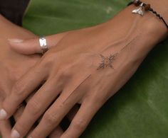 a woman's hand with a small star tattoo on it