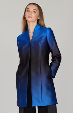 An effortless long duster jacket with a high neckline. Cut in a subtle gradient print to offers a pop of color and a flattering illusion waistline. This jacket has pockets and is finished with a hook & eye closure at the center front. Blue Silk Outerwear For Fall, Fitted Evening Outerwear With Stand Collar, Formal Blue Outerwear With Stand Collar, Fitted Outerwear With Stand Collar For Evening, Sleek Evening Outerwear For Spring, Blue Outerwear With Concealed Placket, Sleek Silk Outerwear For Spring, Sleek Silk Spring Outerwear, Sleek Silk Fitted Outerwear