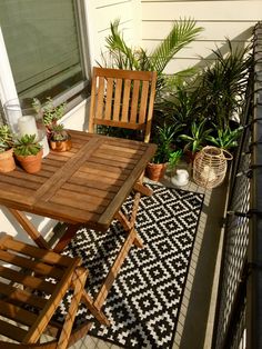 an image of a small balcony with plants on the table and two people sitting at the table