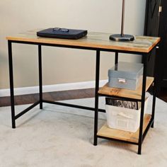 a computer desk sitting on top of a carpeted floor next to a white wall