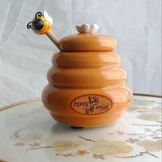 a honey jar with a bee on top