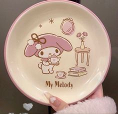 a person holding up a plate with a cartoon character on the front and side of it