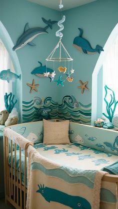 a baby's room decorated in blue and white with sea animals hanging from the ceiling