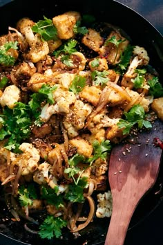 a skillet filled with food and a wooden spoon