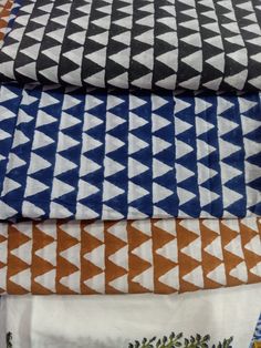 four different colored fabrics are stacked on top of each other, one is orange and the other is blue