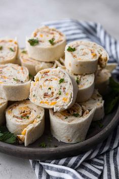 a plate filled with rolls covered in cheese and garnished with parsley on top