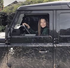 a woman sitting in the driver's seat of a black jeep