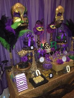 a table topped with lots of purple and gold decorations