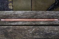 a metal tube sitting on top of a wooden bench