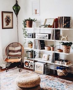 a living room filled with lots of books and plants