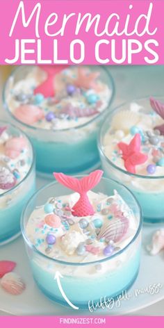 four little mermaid jello cups on a white plate with pink and blue sea shells