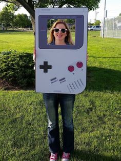 a woman holding up a cardboard board with a video game on it's face