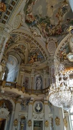 an ornate room with chandeliers and paintings on the walls