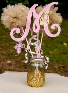 there is a mason jar with some flowers in it and the initials are on top