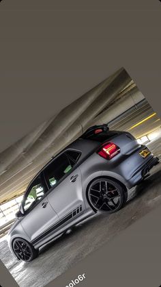 the rear end of a silver car parked in a parking garage