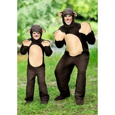 two people in monkey costumes standing on grass