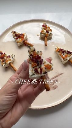 a person is holding some food on a plate with the words cheesy treats