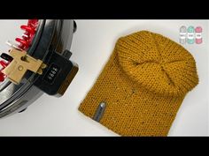 a yellow knitted sweater next to a metal object with red pins on the side