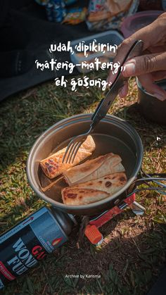 a person is holding a fork in a pan with food on the ground next to some cans