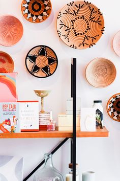 several plates are hanging on the wall above a table with candles and other decorative items