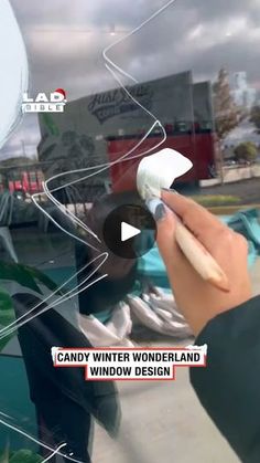 a hand holding a white toothbrush in front of a window with the words candy winter wonderland written on it