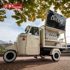 an ice cream truck parked in front of a tree