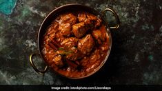 an overhead view of some food in a pot on a table with a spoon and fork