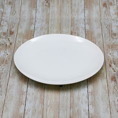 a white plate sitting on top of a wooden floor