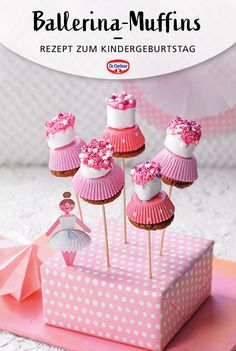 cupcakes with pink frosting and decorations on top are sitting in a box